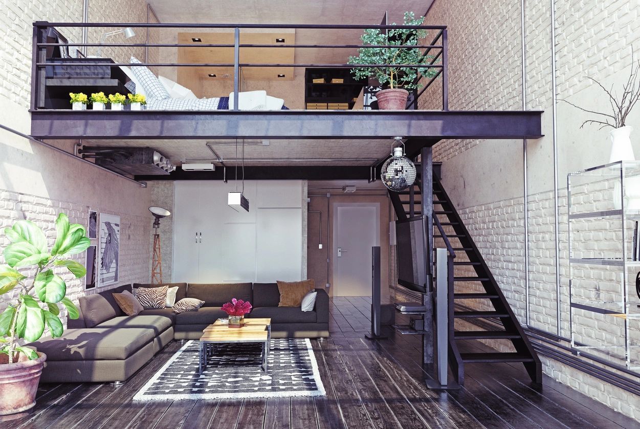 image showing the interior of a space with black wood flooring, black metal framing for the mezzanine with the living room below the bedroom. An example perhaps of adaptive reuse of space and retrofitting